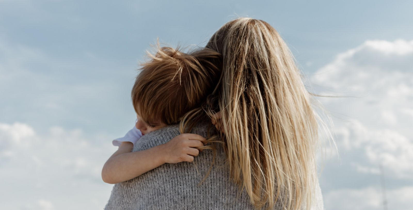 Image of a mother holding her little boy as he hugs her