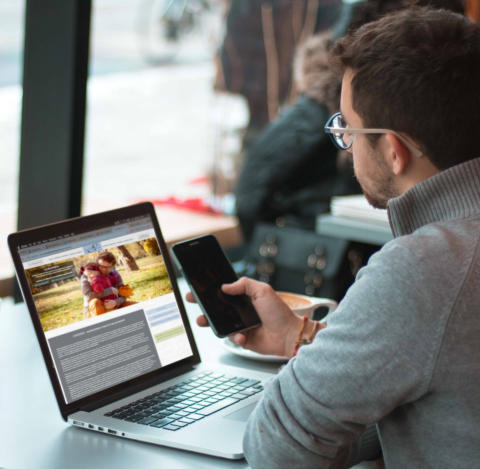 Image of man looking at the Sams Legal web site on his laptop and holding his phone