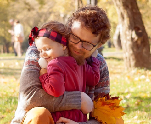 Image of a happy father hugging his smiling little girl