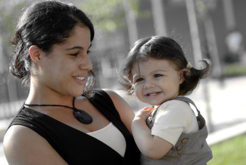 Mom similng and holding her toddler daughter